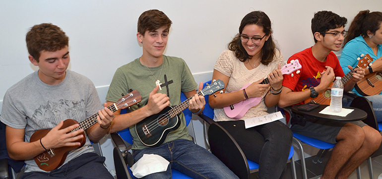 Young members of Sacred Heart Church in Homestead warm up on ukuleles at the Instruments of Peace retreat. From left are Mateo Oliva, Joshua Kuehne, Daniella Reyes and Alexander Arenas.
