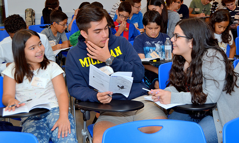 Three attendees at the Instruments of Peace retreat work an exercise in scheduling music for Mass. From left are Seychelles and Dillon D'Andrea of Little Flower parish in Hollywood, and Emily Lantigua of St. Mark in Southwest Ranches.