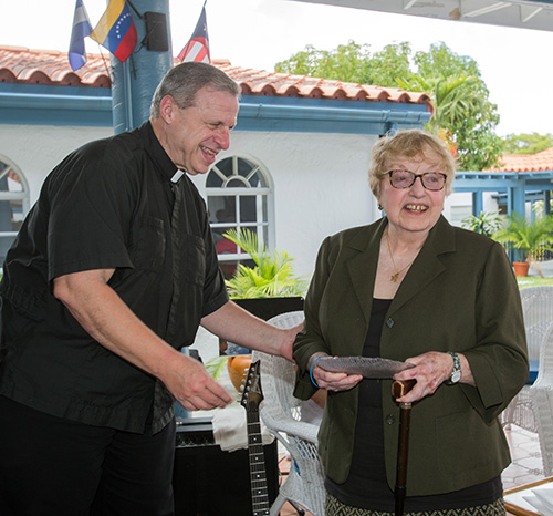 Mons. Pablo Navarro entrega a Zoila Díaz, la segunda directora de la Oficina de Ministerios Laicos, un símbolo de reconocimiento por sus años de servicio.