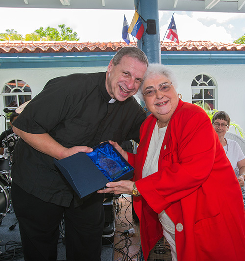 Mons. Pablo Navarro posa para la foto con Leyla Mazpule, que recibió una flama de vidrio por ser la ministra laica más antigua. Ella es de la clase original de la Escuela de Ministerio que se graduó, en 1979.