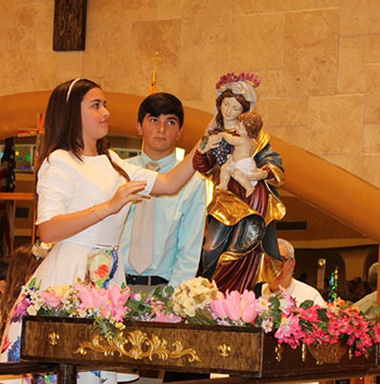St. Kevin School eighth-graders Alexa Garcia and Andre Gonzalez crown an image of the Virgin Mary at the conclusion of a Mass in honor of the month of Mary.