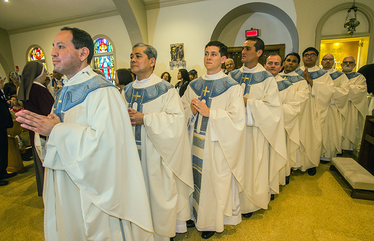 Los nueve sacerdotes recién ordenados esperan para tomar su lugar alrededor del altar de la Catedral St. Mary para la Liturgia de la Eucaristía. De izquierda a derecha: P. Luis Flores, P. Edgardo "Gary" De Los Santos, P. Alexander Rivera, P. Juan Carlos Salazar, P. Oswaldo Agudelo, P. Mathew Padickal Thomas, P. James Arriola, P. Luis Pavón y P. Joseph Maalouf.