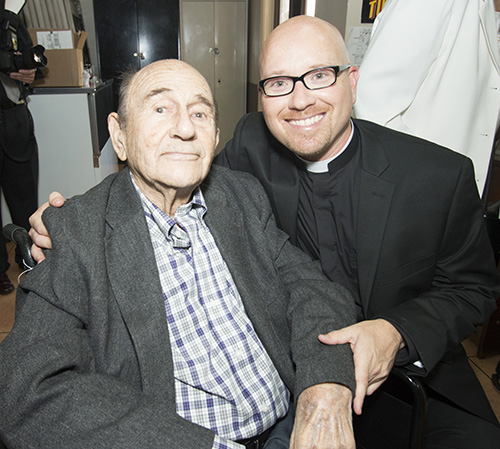 El recién ordenado P. Luis Pavón posa con su homónimo y abuelo, Luis Rodríguez Iznaga, quien estaba celebrando su 98 cumpleaños, el día de la ordenación de su nieto. El abuelo Luis había considerado el sacerdocio cuando era joven, pero dijo que las circunstancias de la vida interfirieron en ese momento. Ahora su nieto cumplirá ese sueño.