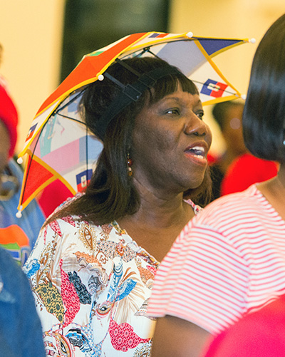 Antonia Charlot wears a Haitian flag umbrella during the Mass for Haitian Flag Day May 18 at Notre Dame d'Haiti Church.