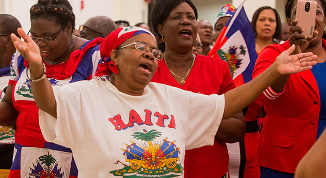Florette Dalice sings along to Haitian music at the start of the Mass for Haitian Flag Day May 18 at Notre Dame d'Haiti Church.
