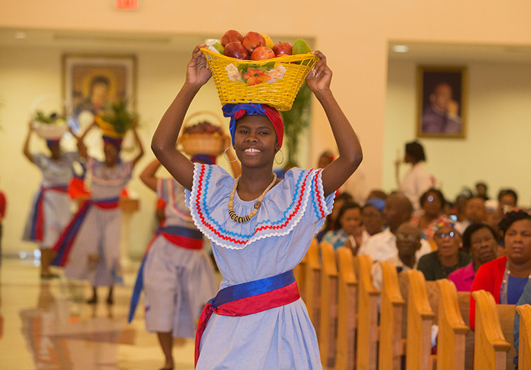Shedwigecka Cherizar brings up the offertory along with other members of Notre Dame d'Haiti's Mime Ministry during the Mass celebrating Haitian Flag Day May 18 at Notre Dame d'Haiti Church.