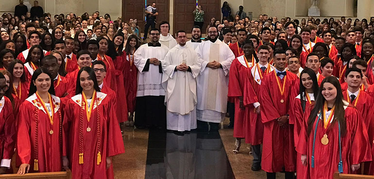 Msgr. Edward Pace High School's Class of 2017 pose for a photo after their baccalaureate Mass with, from left: altar server Alex Gomez (Class of 2011); Pace President Father Paul Vuturo; Father Bryan Garcia (Class of 2006); altar server Mark Gomez (Class of 2013); and Deacon Matthew Gomez (Class of 2009).