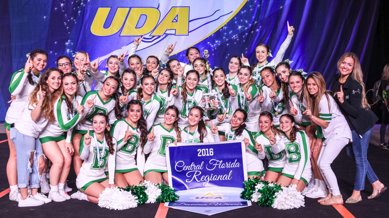Members of St. Brendan High's cheerleading team, already state champions in Competitive Cheerleading, pose at the Universal Cheerleaders Association's Central Florida Regional, where they won the Super Varsity division and qualified to compete in the national championship, to be held next February in Disney World. Also in the photo are Coach Victoria Salazar (second from left), Coach Cecilia Esteban (second from far right) and Head Coach Arlenee Suarez (far right).