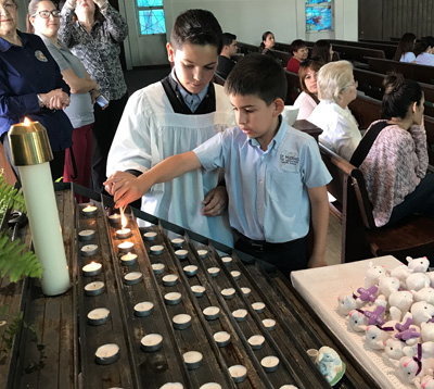 St. Michael the Archangel School students light candles during a first Communion retreat.