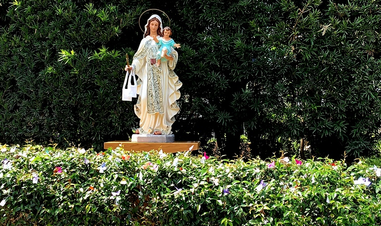 Mary statue at Our Lady of Mercy Cemetery is surrounded by message tags and butterflies made of feather.