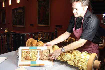 Ulises Acosta explica el proceso de preparación de la madera para colocar el pan de oro. Acosta es uno de los tres especialistas que están colocando pan de oro en los altares de la Iglesia-Museo La Merced, de la parroquia Corpus Christi, en Miami.