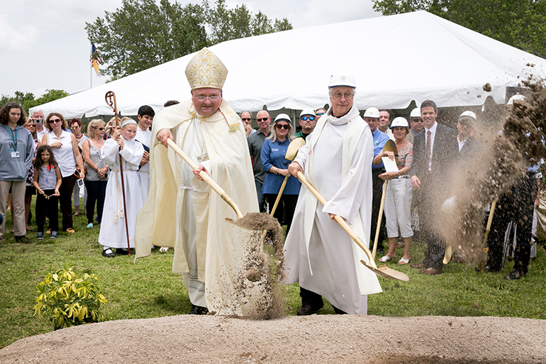 Miami Auxiliary Bishop Peter Baldacchino, left, and Father Thomas Wisniewski, who was pastor until his retirement June 1, break ground May 24 for a new Mary Help of Christians Catholic School Parish & Student Center.