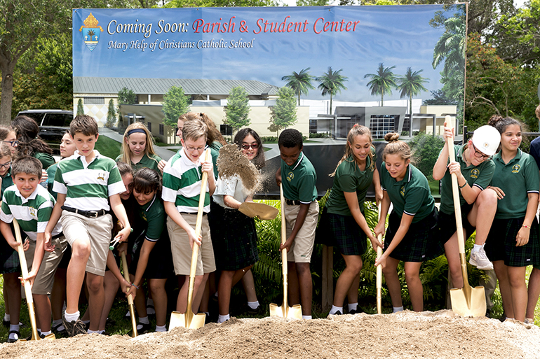 Students lend a hand at the May 24 groundbreaking for a new Mary Help of Christians Catholic School Parish & Student Center. The $ 3.2 million, 15,000-feet structure will allow students to eat lunch inside as well as provide additional space for administrative offices and classrooms.