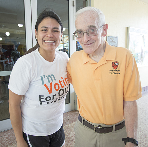 Lucia Báez, graduada en 2001 de Archbishop Curley-Notre Dame, posa con su ex profesor de inglés, y el entrenador de cross-country de la escuela, el Hno. John Corcoran. "Me recordó, estoy muy orgullosa", dijo Báez, quien siguió sus pasos convirtiéndose en profesora de inglés. Ella trabaja en Miami Beach Senior High.