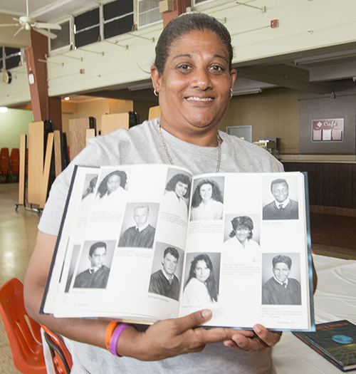 Frances Fresneda, a 1989 graduate of Archbishop Curley Notre Dame High School, poses with her yearbook picture. She now teaches physical education at St. James School in North Miami. "Sports kept me out of trouble. They changed my life. The coaches were like family. They were strict. They kept me straight." For the past 12 years, her former students at St. James, when graduating from Curley Notre Dame, have honored her as the teacher that most inspired them.