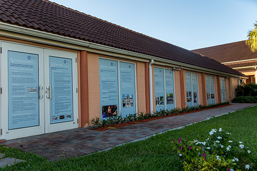 The glass doors on the east side of Our Lady of Lourdes Parish Hall are covered with information about the various programs and activities for the sick in Lourdes, France.