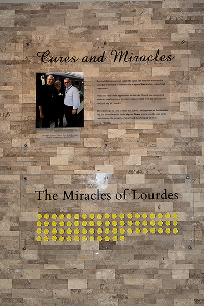 The "wall of miracles" at Our Lady of Lourdes in Miami explains the significance of the many miracles that have occurred in Lourdes, France. The yellow flowers stand for each of the officially declared miracles of Lourdes.