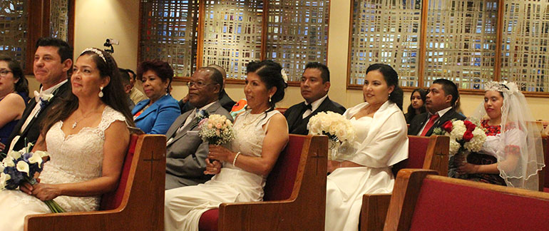 Four brides and four grooms listen during their group wedding ceremony June 3 at St. Martha Church. From left:  Calogero "Lillo" Tirone and his wife Marlene Esguerra, Leonard Lawrence and his wife Zenaida Leon, Sergio Morales and his wife Iris, and Juan Pelico Abac and his wife Egidia Cuynch.