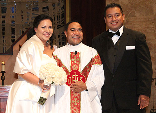 Meet the newlyweds: Iris and her husband, Sergio Morales, pose with Father Wilfredo Contreras.
