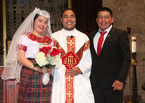 Meet the newlyweds: Egidia Cuynch and her husband, Juan Abac Pelico, pose with Father Wilfredo Contreras.