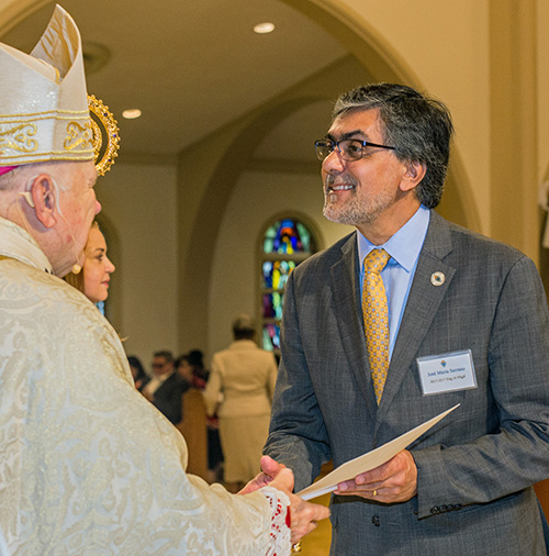 Jose Maria Serrano, of the English-language class at St. Hugh, receives his certificate of completion from Archbishop Thomas Wenski.