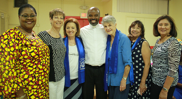 Our Lady of Lourdes MACCW members pose with their former parochial vicar, now St. Stephen’s pastor Father Patrick Charles, at the Haitian Mass and reception held at his parish in Miramar June 11. From left: Josephine Gilbert, Nancy Gonzalez, Sharon Utterback, Anne Santos, Patricia Van Bresselin, and Joan Tai.