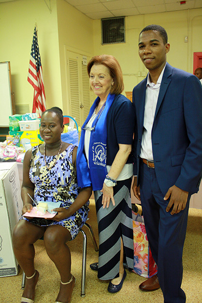 Layette recipient and expectant mom Shirley Raphael (seated) poses with MACCW President Sharon Utterback and Raphael’s husband, Jean Duemy.