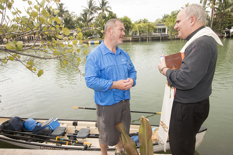 Father Roberto Cid, pastor of St. Patrick Church, Miami Beach, speaks with Greg Dougherty, who is embarking on a 1,400-mile sea journey from Miami to New York.