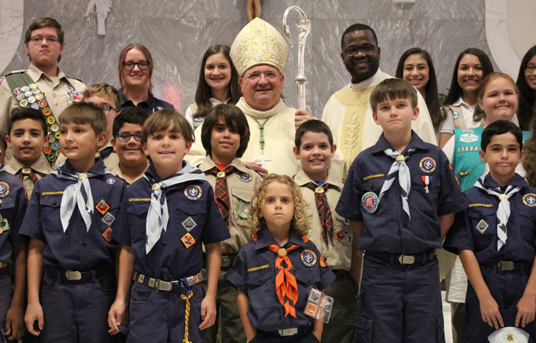 Remembering the Scouting days: Auxiliary Bishop Peter Baldacchino and Chancellor for Canonical Affairs and Vicar General Msgr. Chanel Jeanty pose with Scouts from throughout the Archdiocese of Miami who celebrated a Catholic Scouting Mass at St James Parish on June 10. Both Bishop Baldacchino and Msgr. Jeanty particpated in Scouts when they were young.