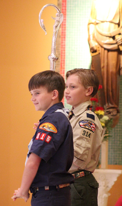 Nikolai Moise (in blue) and Benjamin Colby assist at the altar during Mass.