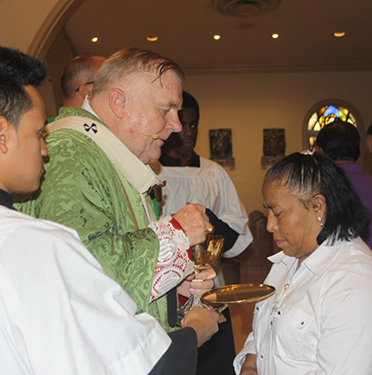 Guadalupe Hernández, una empleada del hogar, recibe la Eucaristía del Arzobispo Thomas Wenski durante la Misa por el reconocimiento del trabajo de las empleadas domésticas, en la Catedral St. Mary.