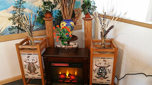 An artificial fireplace and Native American sand art decorate a corner of El Cristo Rey Chapel, located inside Grand Canyon National Park.