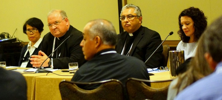 Panelists discuss how to minister to immigrants during the Convocation of Catholic Leaders in Orlando. Sitting at the table, from left, are Sister Myrna Tordillo, a staff member with the United States Conference of Catholic Bishops; Auxiliary Bishop Peter Baldacchino of Miami; Auxiliary Bishop Daniel Garcia of Austin, Texas; and Corinne Monogue of the Diocese of Arlington, Va.