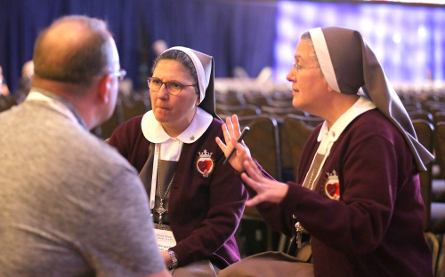 Sister Ana Margarita Lanzas, left, and Mother Adela Galindo take part in a small group conversation at the Convocation of Catholic Leaders in Orlando. Both sisters are part of the Servants of the Pierced Hearts of Jesus and Mary, a religious order based in Miami.