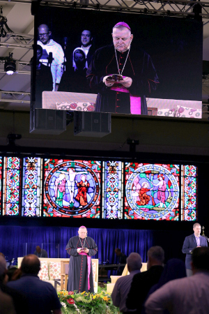 Archbishop Wenski's projected image looms large behind him as he addresses the Convocation of Catholic Leaders in Orlando.