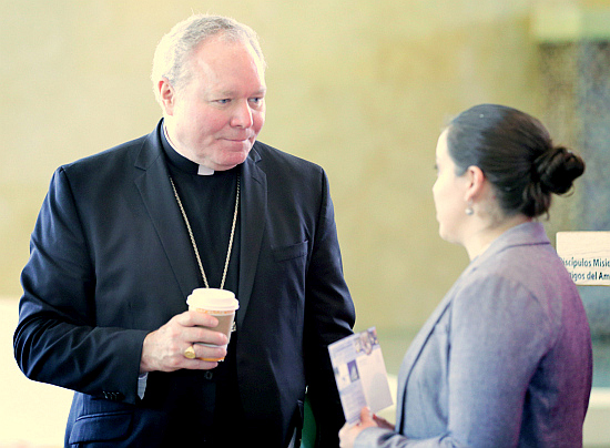 Dallas Bishop Edward Burns, one of the emcees of the keynote presentations and panel discussion, "Going to the Peripheries," talks with an attendee at the 2017 Convocation of Catholic Leaders  July 3 in Orlando. Bishop Burns set the tone for one of the key conversations at the convocation.