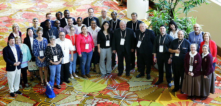 Some of the 40 attendees from the Archdiocese of Miami gather for a group portrait at the end of the Convocation of Catholic Leaders in Orlando. Fourth from the right in front is Archbishop Thomas Wenski; to his right is Auxiliary Bishop Peter Baldacchino.