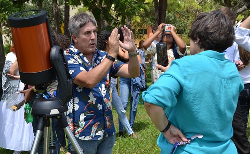 David Quesada, associate professor of natural science at St. Thomas University, explains the eclipse viewing to Ana Rodriguez-Soto, editor of The Florida Catholic.