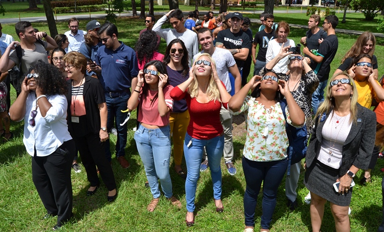 Students, staff and faculty at St. Thomas University gaze at the solar eclipse through special glasses.