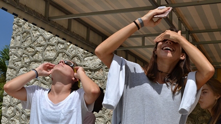 Nursing students Katerina Alvarez, left, and Daniella Piloto gaze sunward during the solar eclipse over St. Thomas University.