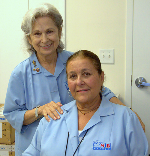 Ady Viera, de pie, con su colega voluntaria Teresita Michelena, en la Clínica San Juan Bosco.