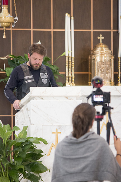 Gabriel Frohlich, aka Magyar, one of the founders of the Emmaus Bikers of Our Lady of Guadalupe Parish, proclaims the first reading at the Mass Aug. 5 that marked the start of Archbishop Thomas Wenski's ride to Key West with Great Adventure Ministries' Bear Woznick. The ride will be featured in the second season of Woznick's "Long Ride Home" reality series on EWTN.