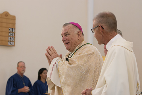 Archbishop Thomas Wenski, flanked by Father John Baker, rector of the Basilica of St. Mary Star of the Sea, begins the Eucharistic celebration at the Key West church before setting out on his motorcycle ride back to Miami Aug. 6. The ride will be featured in the second season of Bear Woznick's "Long Ride Home" reality series on EWTN.