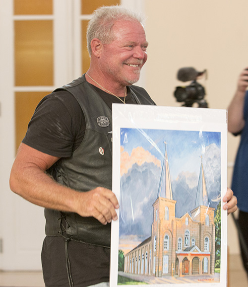 Bear Woznick shows off the souvenir he received during his stop at the Basilica of St. Mary Star of the Sea. Archbishop Thomas Wenski's motorcycle ride to Key West will be featured in the second season of Woznick's "Long Ride Home" reality series on EWTN.