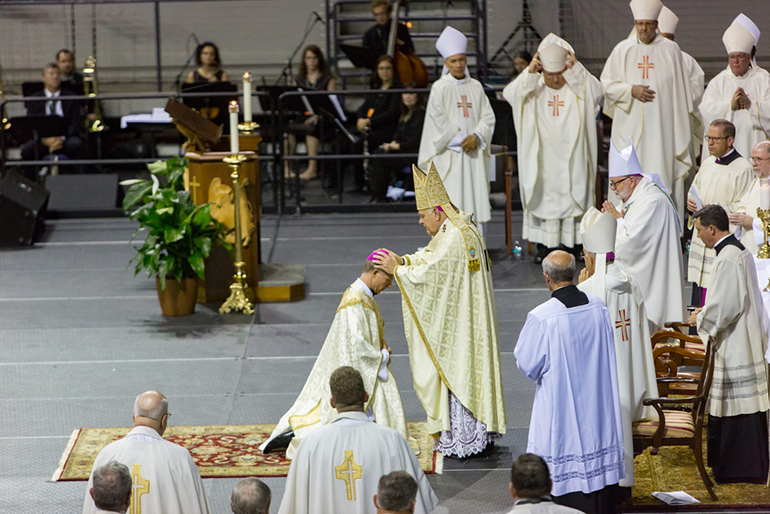 Archbishop Thomas Wenski lays hands over Bishop-elect William Wack, ordaining him to the episcopacy. Thousands of the faithful gathered at the Pensacola Bay Center Aug. 22, while others watched worldwide via the web, the ordination and installation of the sixth bishop of Pensacola-Tallahassee, Bishop William A. Wack, a member of the Congregation of Holy Cross.