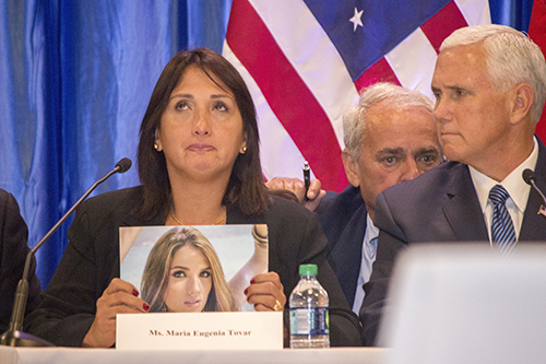 El vicepresidente Mike Pence mira a María Eugenia Tovar mientras esta sostiene una fotografía de su hija de 22 años, asesinada por una bala, en una protesta en marzo de 2014. Detrás de ellos se encuentra un traductor.