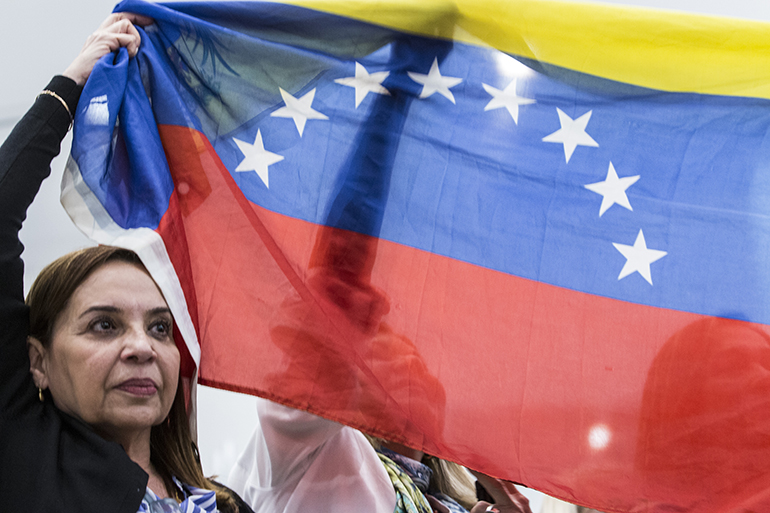 Dos mujeres sostienen la bandera venezolana al finalizar el discurso del Vicepresidente, Mike Pence, en la iglesia Our Lady of Guadalupe, en El Doral.