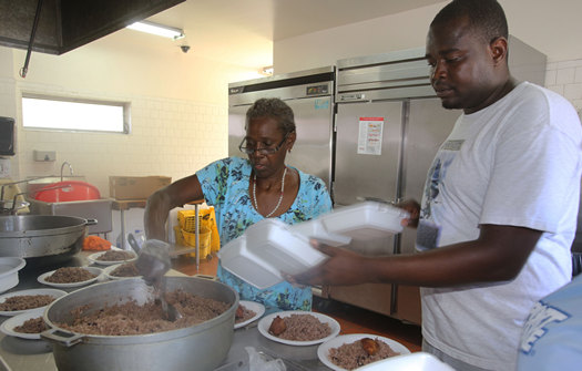 El seminarista Alix Sylien y Tercilia Colas preparan comidas en la iglesia Holy Family, de North Miami, para distribuirlas a la comunidad después del huracán Irma.