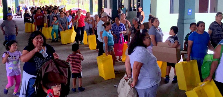 Parishioners line up for food distribution at San Juan Chapel in Florida City.