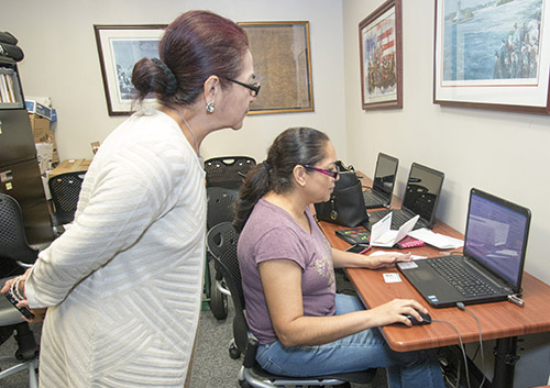 Esperanza Montaldo, a citizenship accredited representative with Catholic Legal Services, watches as client Sonia Hernandez fills out the application for U.S. citizenship at the agency's downtown Miami office.